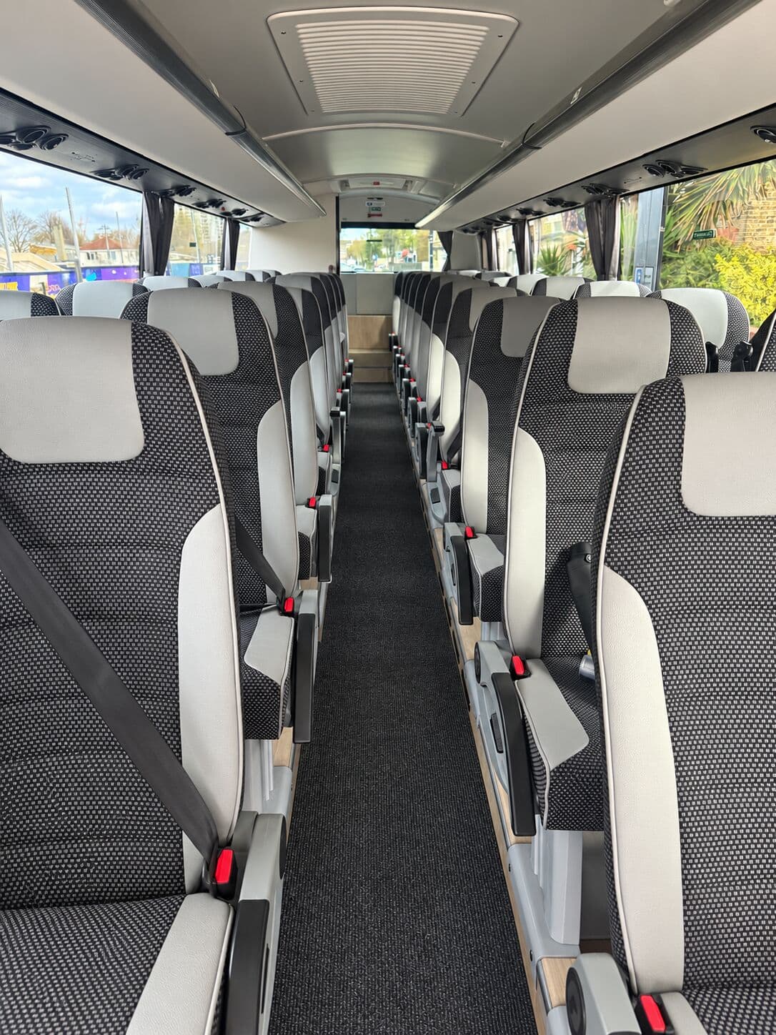 Inside the Volvo B8R coach: grey and cream seats with overhead lockers